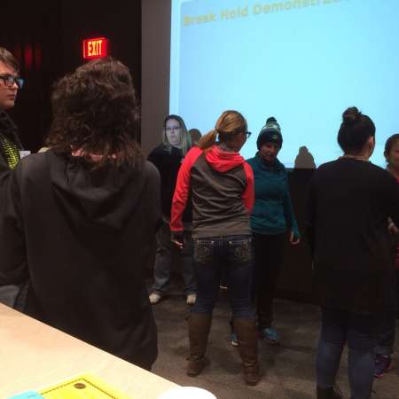 Students and parents practice self defense presentation.