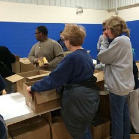Karen works with group to pack boxes.