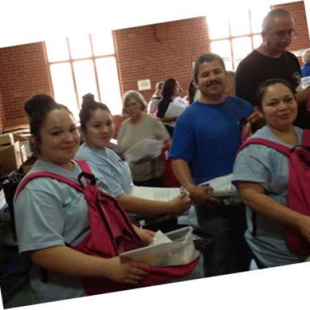 Family works together to stuff backpacks at Pack the Backpacks.