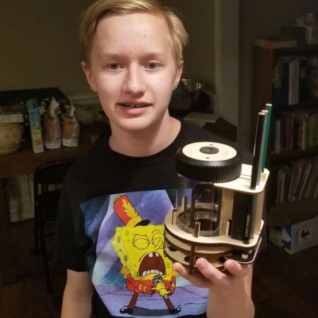 Student showing his successful robotics kit completed