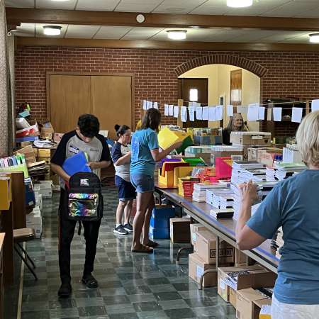 Students and Families preparing backpacks for local students