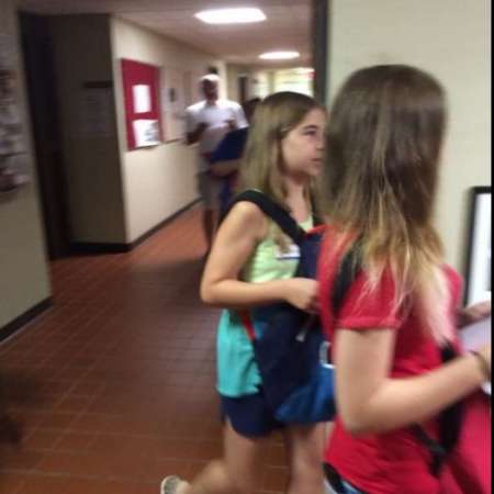 Students fill backpacks with school supplies.