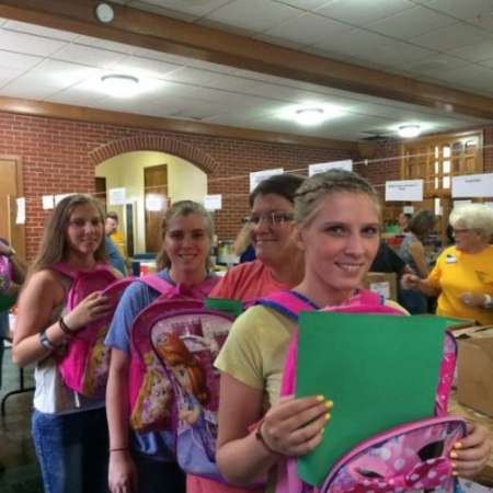Students fill backpacks with school supplies.