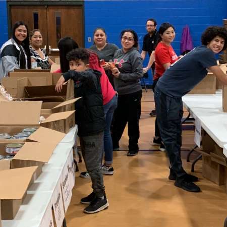 Fernando, Mariel, & Julie volunteer to Prep Salvation Army meal boxes.