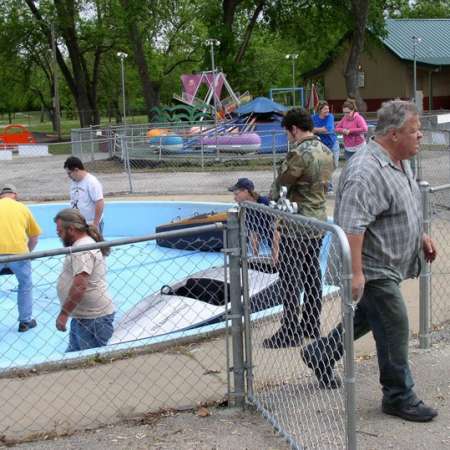 Volunteers clean up Kiddie Park to prepare it for opening weekend.