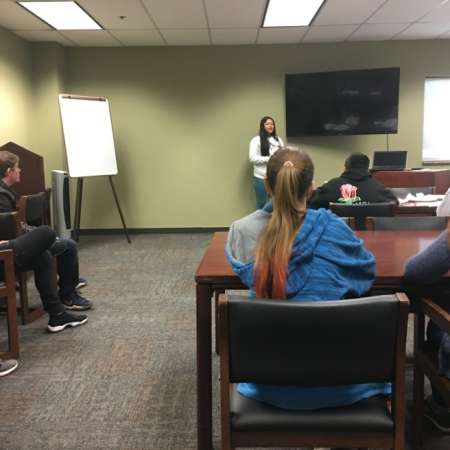 Students listen to others practicing presentations.