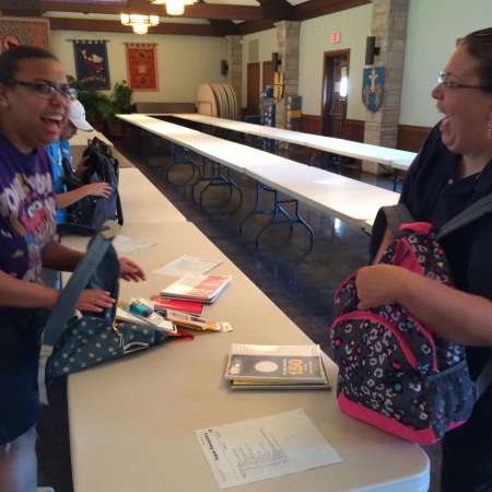 Miracle and Christin have fun while packing backpacks.