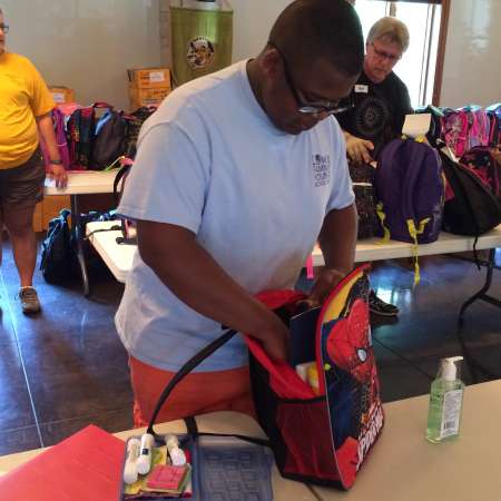 Chris helps pack backbacks.