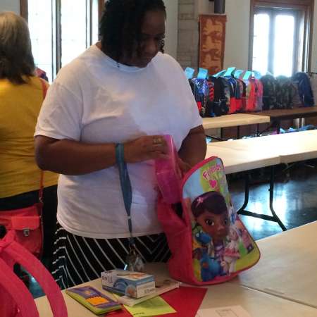 Royelle helps pack backpacks.