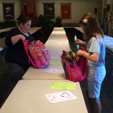 Christina and Valerie check their backpacks.