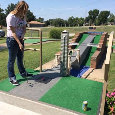 Collyn tries to make a hole in one at the mini golf event.