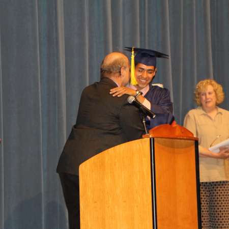 Josue receives his scholarship from mentor Mike.
